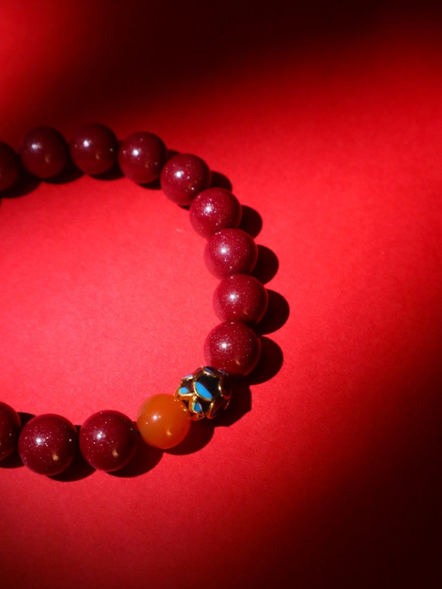 Red beaded bracelet on a red background.